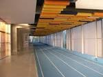 Pasillo interior con pista de atletismo y detalles de diseño en el techo
