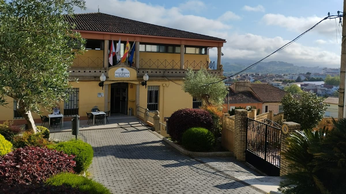 Vista exterior de un edificio con jardín y acceso pavimentado en Vigo