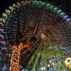 Rueda de la fortuna iluminada de noche con árbol decorado