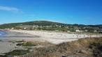 Vista panorámica de la Playa de Barrañán con dunas y edificios distantes