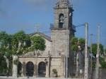 Vista de la Iglesia de Santa Cristina de Lavadores con elementos urbanos y árboles verdes