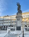 Detalle de la estatua de María Pita con edificios de la plaza al fondo