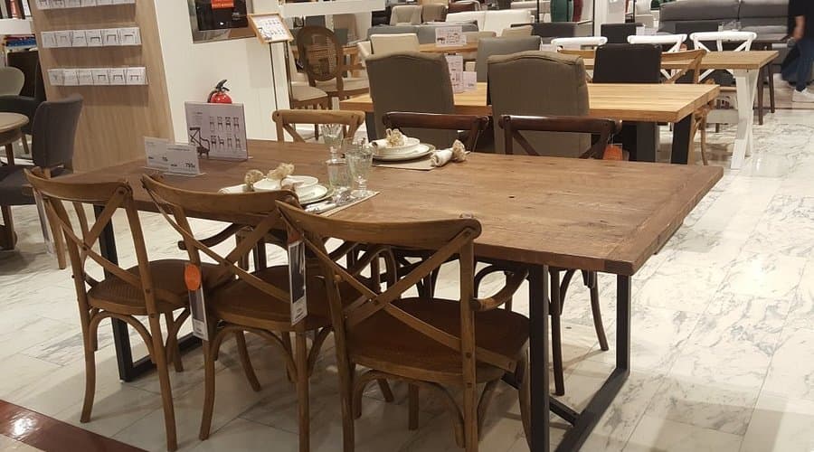 Interior de zona de restauración con mesas y sillas de madera