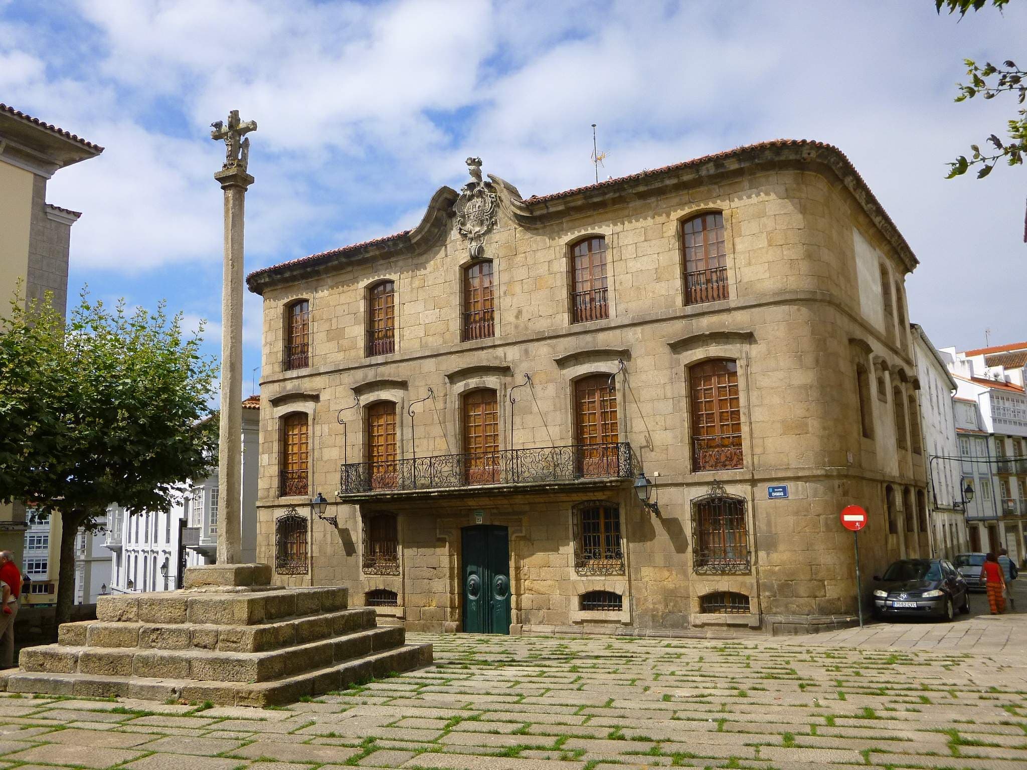 Vista frontal de Casa Cornide y el cruceiro en la plaza