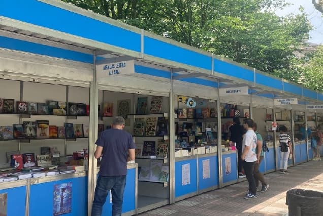 Puestos de la Feria del Libro de Ourense al aire libre con visitantes