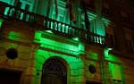 Vista exterior del edificio del Colegio Oficial de Farmacéuticos de Ourense iluminado de verde por la noche