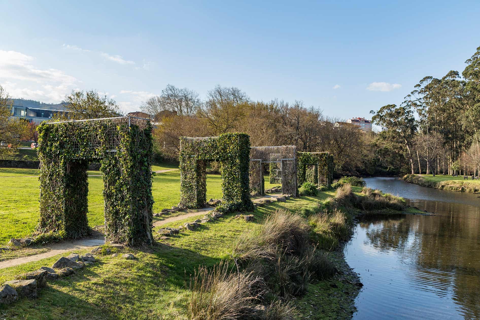 Esculturas de arcos cubiertos de vegetación junto al río