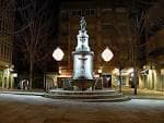 La Plaza de la Princesa iluminada por la noche con la fuente destacada