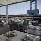 Comedor interior moderno con mesas preparadas y vistas al puerto