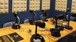 Mesa de estudio de radio con varios micrófonos y auriculares