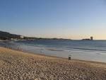 Playa de Samil al atardecer con la arena y el mar en calma