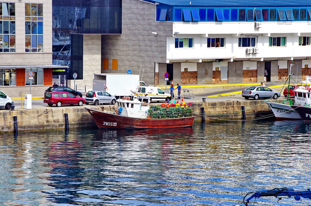 Barco pesquero rojo atracado en el muelle de O Berbés
