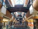 Atrio interior del centro comercial con múltiples niveles y techo acristalado