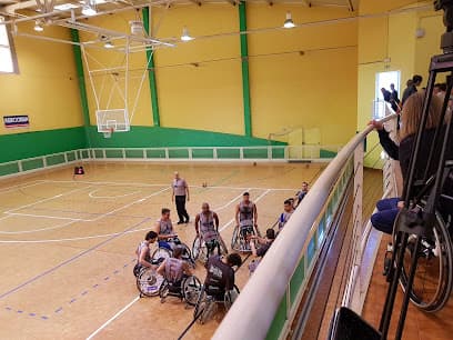 Vista interior del polideportivo con cancha de baloncesto y gradas
