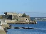 Vista panorámica del Castillo de San Antón desde el mar en un día soleado