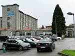 Vista exterior del edificio CIFP Compostela con aparcamiento en un día nublado