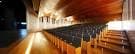 Interior del auditorio con filas de butacas y techo de madera