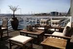 Terraza exterior con mobiliario lounge y vistas al puerto deportivo