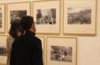 Visitantes observando fotografías en una exposición dentro de la sala
