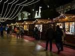 Vista nocturna del Mercado de Nadal con luces festivas y gente paseando entre los puestos