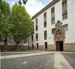 Fachada principal de la Facultade de Filosofía y patio pavimentado