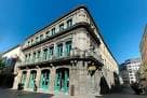 Fachada de la biblioteca desde una perspectiva de esquina bajo cielo azul