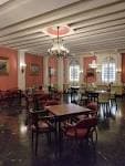 Elegante salón interior del Casino Ferrolano con paredes rojizas y mobiliario clásico