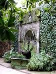 Fuente de piedra antigua cubierta de musgo en los jardines del Pazo