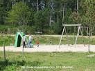 Zona de juegos infantiles con columpios y un área de césped en el Parque Forestal de Beade