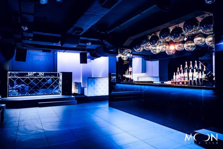 Interior del Moon Music Club con escenario y barra iluminados en azul