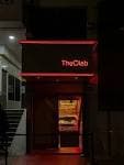 Entrada exterior de The Clab por la noche con el letrero iluminado