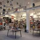 Interior moderno de la librería Lectocosmos con estanterías llenas de libros y mesas de exposición