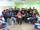 Grupo de estudiantes en un aula o sala de formación con paredes verdes