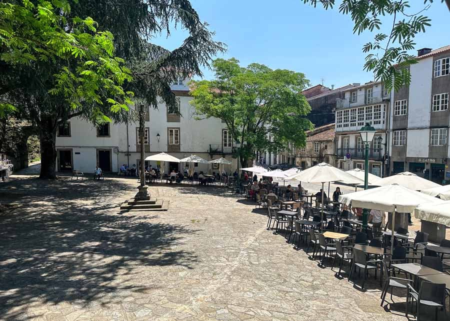 Plaza 8 de Marzo con mesas al aire libre y vegetación
