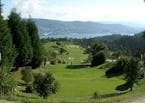 Campo de golf con fairways verdes y la ría de Vigo en el horizonte