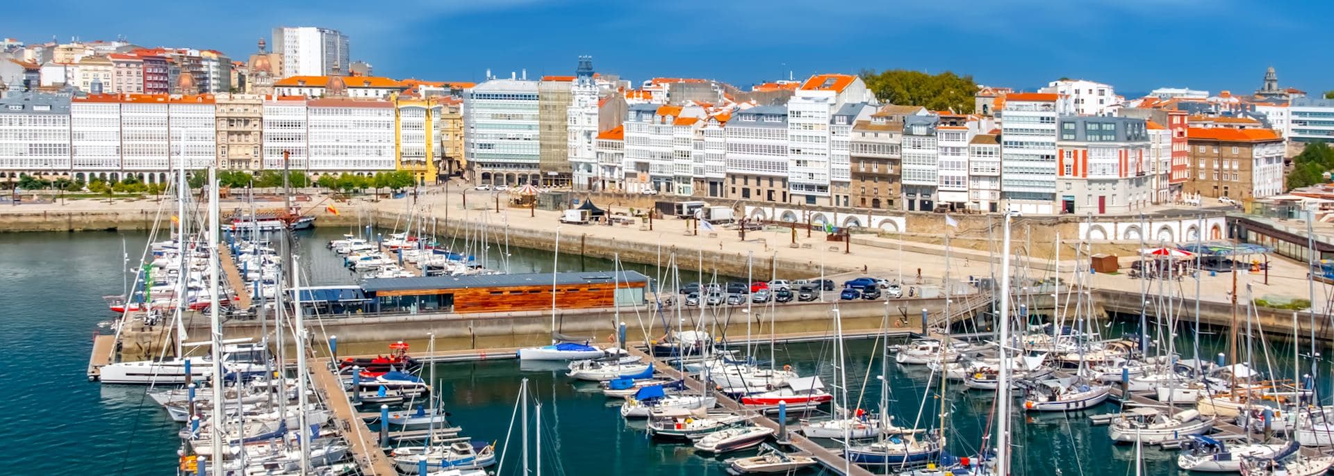 Panorámica de la Marina Coruña con embarcaciones y edificios históricos.