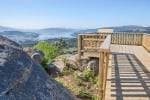 Plataforma de madera en un mirador con barandilla y vistas al paisaje