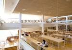 Interior espacioso de la Biblioteca del Campus de Ourense con zonas de estudio