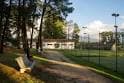 Vista de un edificio y canchas de tenis rodeadas de árboles en el complejo