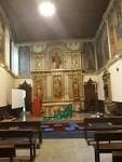 Interior de la Capilla de la Oficina de Acogida al Peregrino con retablo dorado