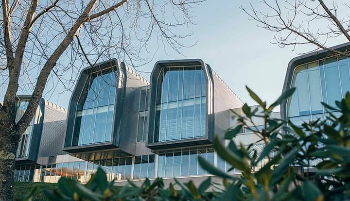 Vista exterior del moderno edificio CINBIO con grandes ventanales y vegetación