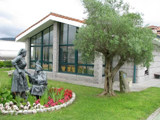 Jardín exterior del albergue con estatua y vista del edificio
