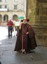 Persona disfrazada de peregrino tradicional en una plaza de Santiago