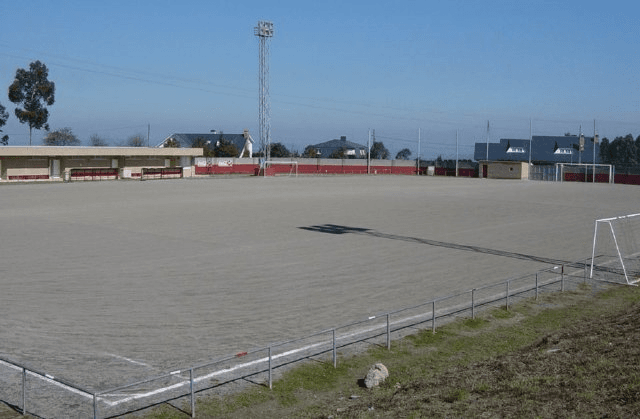 Vista general del Campo Municipal de Fútbol A Zapateira con campo de tierra y gradas