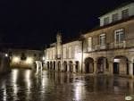 Plaza da Pedreira de noche con el suelo mojado reflejando las luces