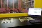 Sala de control de radio con mesa de mezclas y monitor