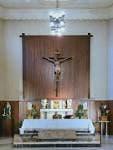 Altar mayor de la Parroquia de Santa Teresita con crucifijo y candelabros