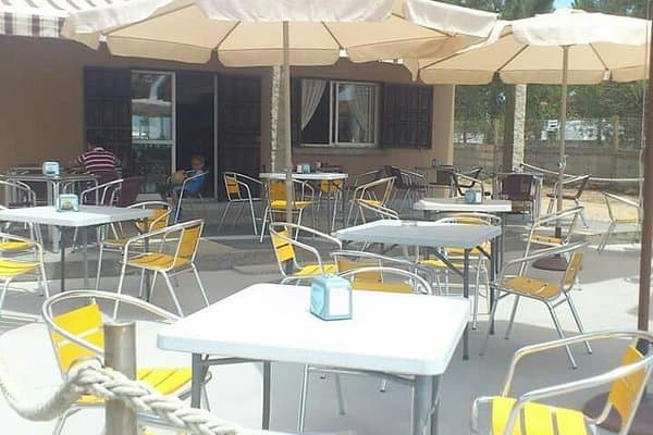 Terraza exterior de chiringuito con mesas y sombrillas