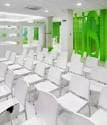 Sala de reuniones o aula con sillas blancas y paredes verdes