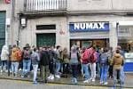 Grupo de personas reunidas en la entrada de NUMAX